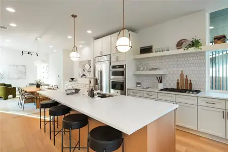 Kitchen with appliances with stainless steel finishes, visible vents, light wood-style floors, and a sink