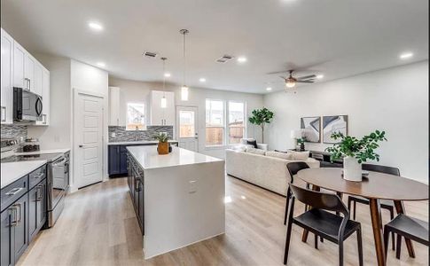 Kitchen with a center island, white cabinetry, stainless steel appliances, and light hardwood / wood-style floors