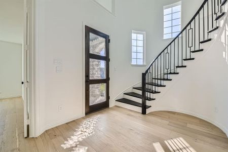 Foyer featuring a towering ceiling and light wood-type flooring