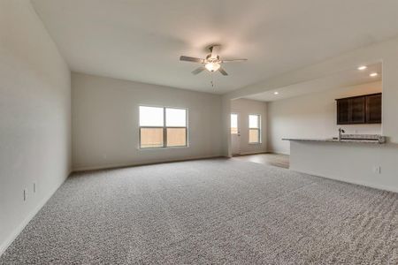 Unfurnished living room with sink, light colored carpet, and ceiling fan