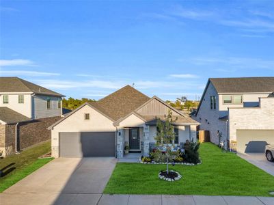 View of front of home with a front lawn and a garage