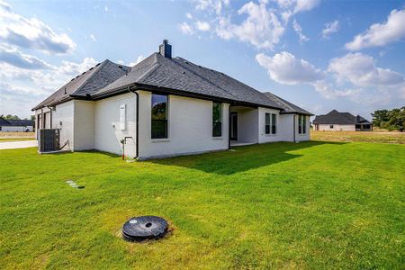 Rear view of property with a lawn and central AC unit