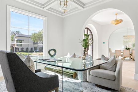 Dining area with beamed ceiling, coffered ceiling, a notable chandelier, and light wood-type flooring