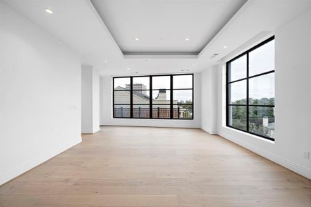 Living room: expansive windows usher in an abundance of natural light, framing picturesque tree views connecting with the outside world.