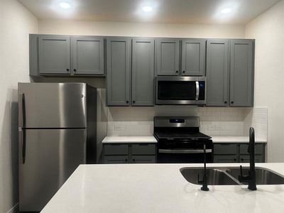 Brand new refrigerator and the modern faucet and cabinet knobs.