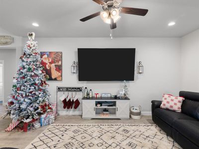 Living room with wood-type flooring and ceiling fan