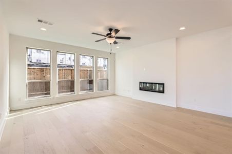 Unfurnished living room featuring ceiling fan and light wood-type flooring