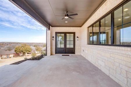 Doorway to property featuring french doors, brick siding, and ceiling fan