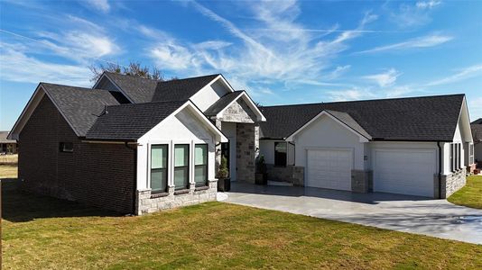 View of front of home with a garage and a front lawn