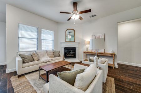 Living room featuring ceiling fan and wood like tile flooring.