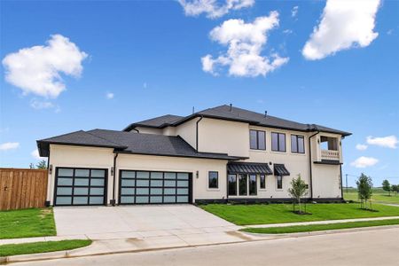 View of front of home featuring a garage, a front lawn, and a balcony