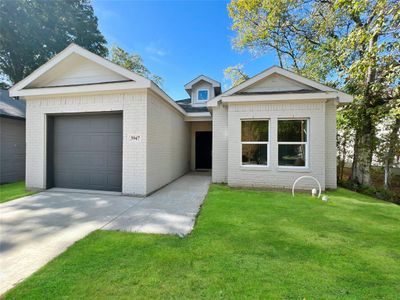 Single story home featuring a garage and a front lawn