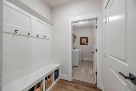 Mudroom with washing machine and clothes dryer and light wood-type flooring