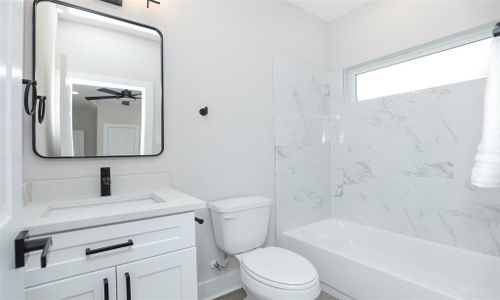 First floor bath with tub and shower. Beautiful gray veined quartz and wrought iron hardware for a clean, modern feel.