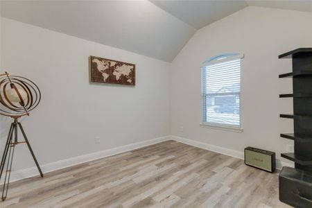 Unfurnished room with vaulted ceiling and light hardwood / wood-style flooring