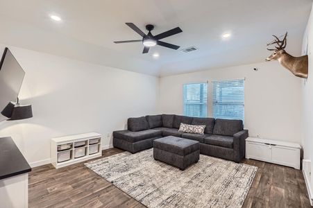 Living room featuring ceiling fan, recessed lighting, baseboards, and dark wood-style floors Living room featuring ceiling fan, recessed lighting, baseboards, and dark wood-style floors