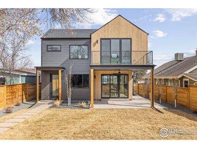 Rear elevation of home. Oversized backyard with newly installed  wood privacy fencing.