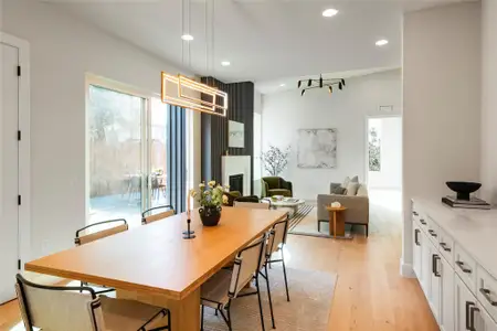 Dining area with a large fireplace, visible vents, light wood-style flooring, and recessed lighting