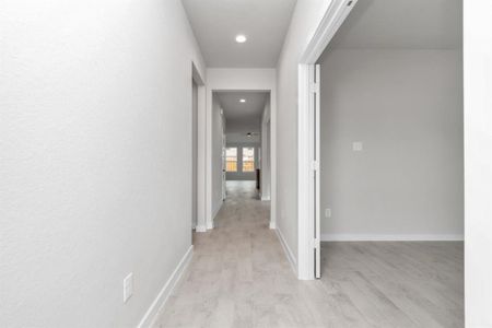 The grand entrance beckons with its soaring ceilings, adorned with elegant wood-look tile flooring featuring sleek oversized baseboards. Sample photo of completed home with similar floor plan. As-built interior colors and selections may vary.