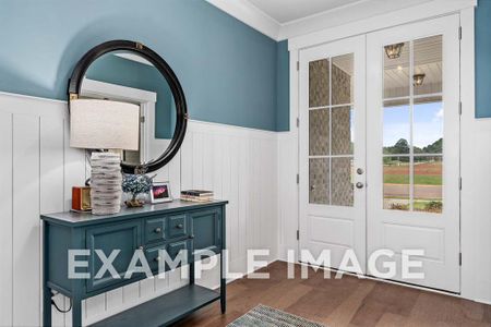 Foyer entrance featuring dark hardwood / wood-style flooring, ornamental molding, and french doors