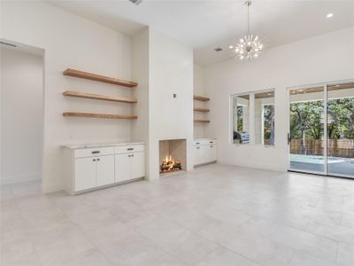 Unfurnished living room with a chandelier, a fireplace, and baseboards