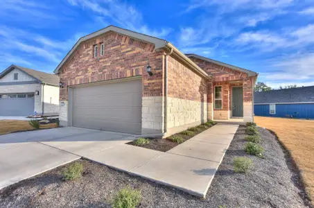 Ranch-style house with stone siding, brick siding, an attached garage, and driveway