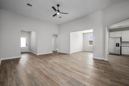 This open floor plan home features high ceilings throughout. The living room is open to the dining room, kitchen, and leads out to a spacious covered patio.