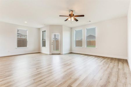 Kitchen with decorative backsplash, sink, a center island with sink, stainless steel range, and light hardwood / wood-style flooring