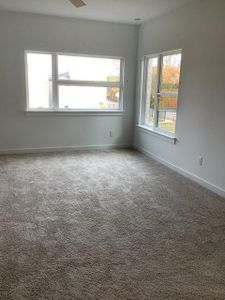 Empty room featuring ceiling fan and carpet floors