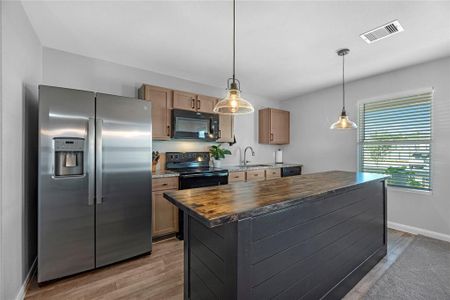 The kitchen boasts a larg island, garbage disposal, and brand new light fixtures