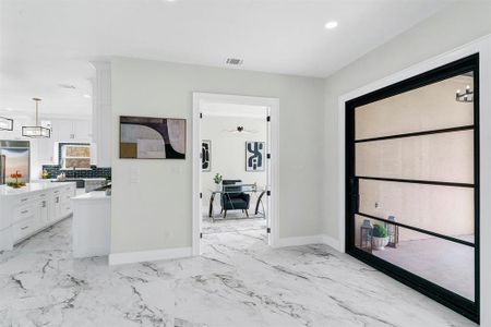 Entryway featuring ceiling fan with notable chandelier