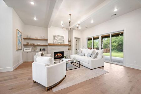 Living room featuring beam ceiling, light hardwood / wood-style flooring, and an inviting chandelier