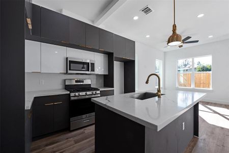 The beautifully appointed kitchen has sleek quartz countertops, stainless steel appliances, and lots of cabinets. There is plenty of storage space for all your prepping and cooking needs. The island offers lots of space to serve and entertain.