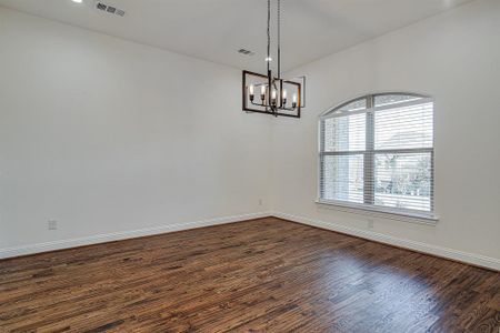 Formal dining room inviting chandelier and dark wood-type flooring