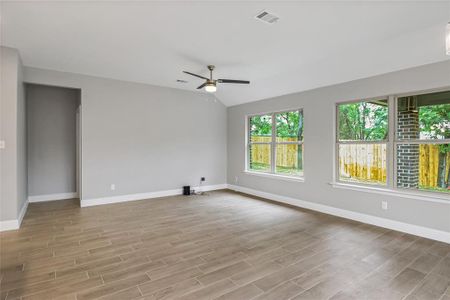 Unfurnished room with ceiling fan, light hardwood / wood-style flooring, and lofted ceiling