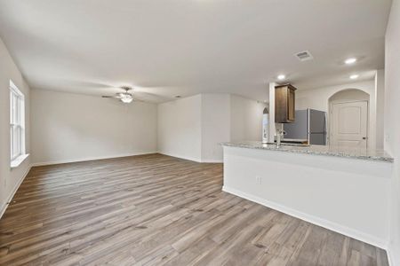 Unfurnished living room with ceiling fan, sink, and light hardwood / wood-style floors