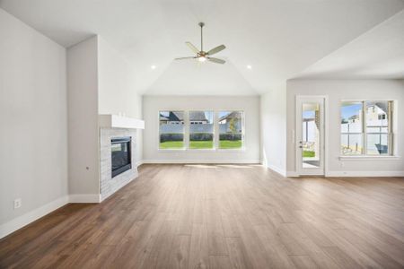 Unfurnished living room with a fireplace, a healthy amount of sunlight, and wood-type flooring