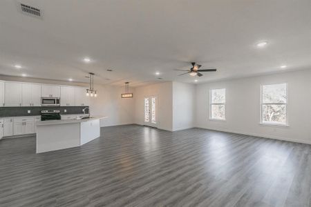 Kitchen with stainless steel appliances, tasteful backsplash, visible vents, open floor plan, and a sink