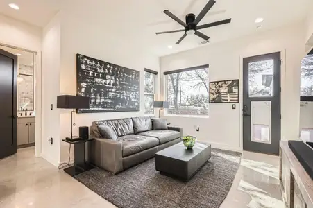 Spacious living area with an abundance of natural light pouring through large windows, highlighting the beautiful concrete floors.