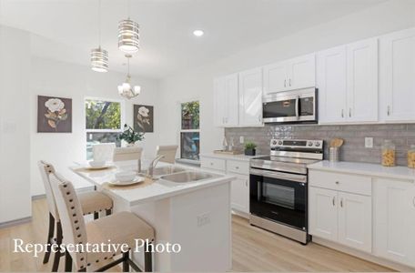 Kitchen with pendant lighting, an inviting chandelier, sink, appliances with stainless steel finishes, and white cabinetry