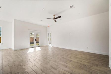 A spacious living area with double doors leading to your covered patio. Complete with a modern ceiling fan, plenty of natural light and ten foot ceilings throughout the home.