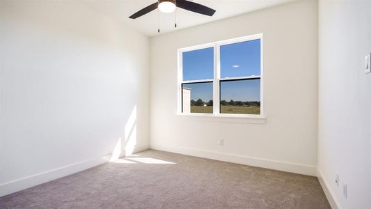 Empty room featuring light colored carpet and ceiling fan