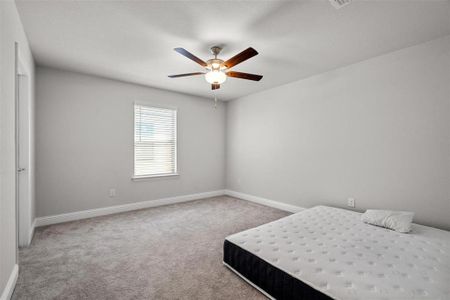 Unfurnished bedroom with carpet flooring and ceiling fan