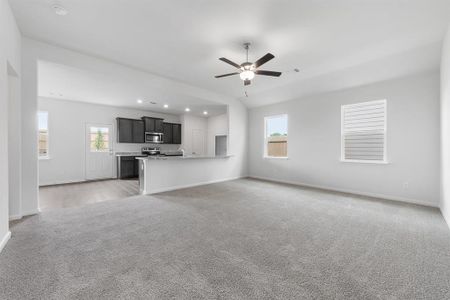 Living room with ceiling fan and light carpet