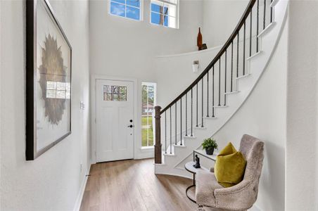 Elegant entryway featuring a spiral staircase and inviting front door.