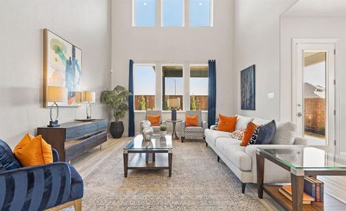 Living room with a towering ceiling and light hardwood / wood-style floors