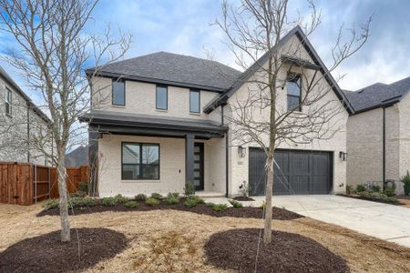 View of front of home with brick siding, driveway, and fence