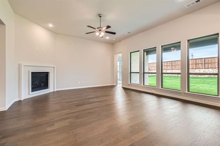 Unfurnished living room with dark hardwood / wood-style flooring and ceiling fan