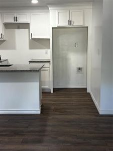 Kitchen featuring white cabinets, dark hardwood / wood-style floors, and stone countertops