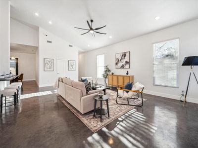 Living room with ceiling fan and lofted ceiling